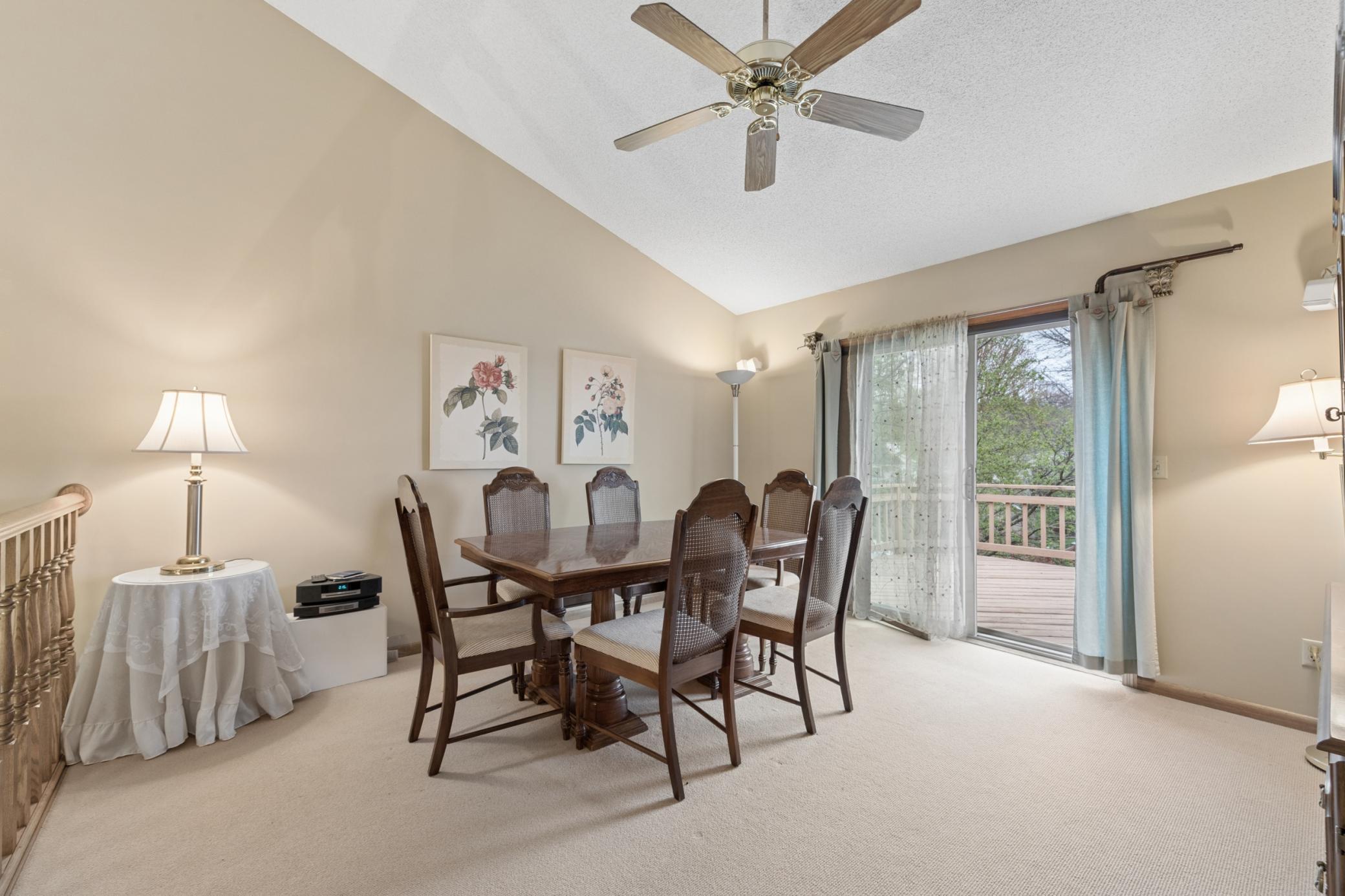 The vaulted upper-level living room with a large patio door that walks out to the deck.