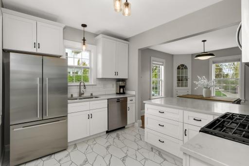 Gorgeous white cabinety kitchen with quartz counters, and stainless steel appliances