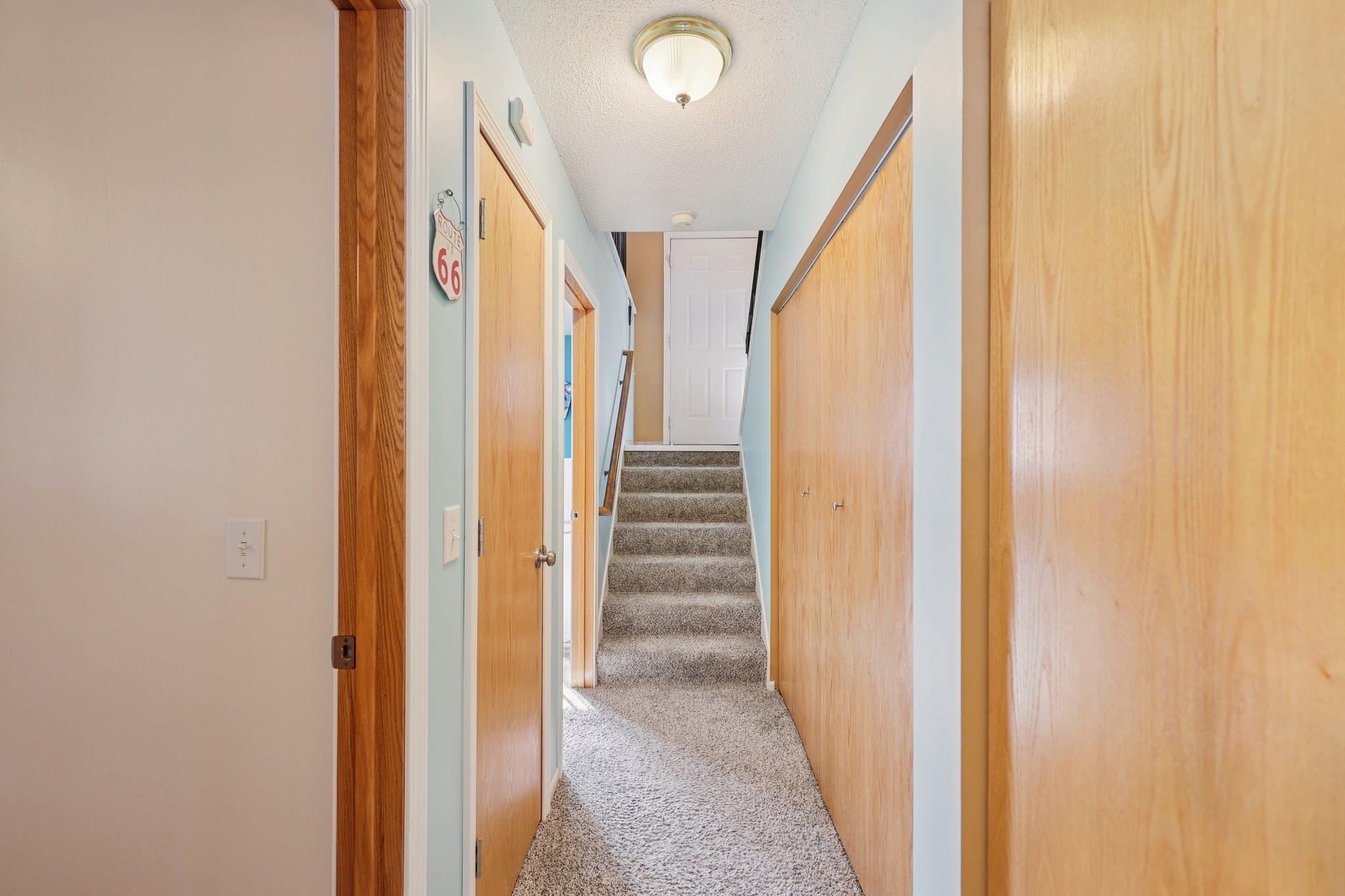 The open door the left of the stairs in this photo is the primary bedroom