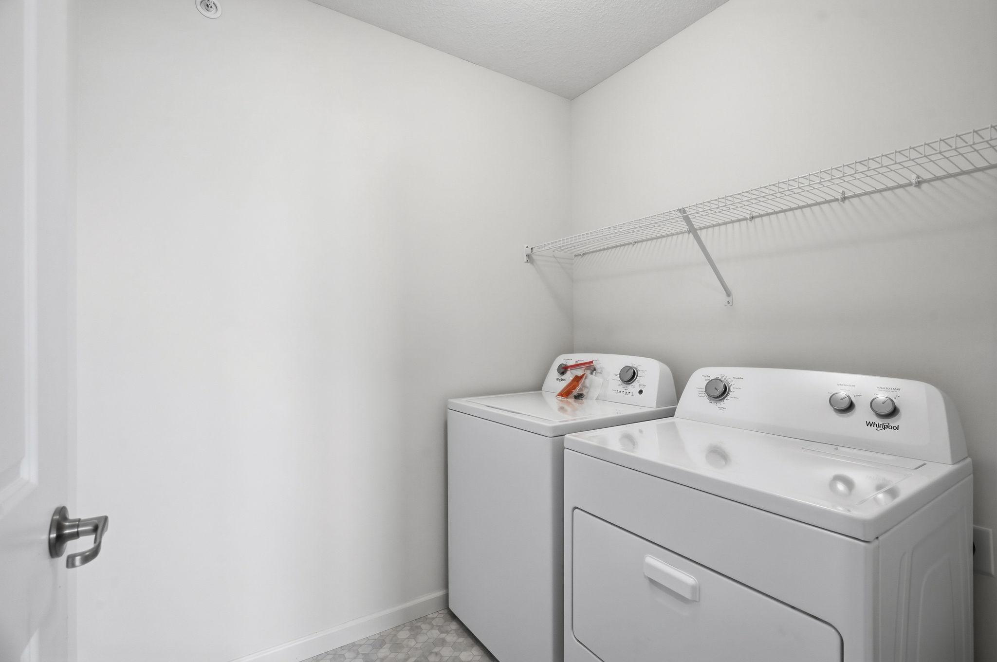 Upper level laundry room at the top of the stairs across from the primary bedroom