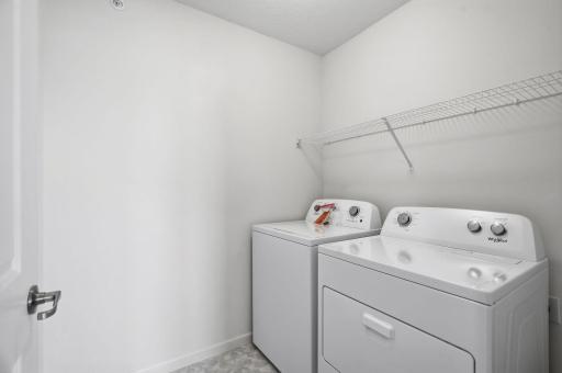 Upper level laundry room at the top of the stairs across from the primary bedroom