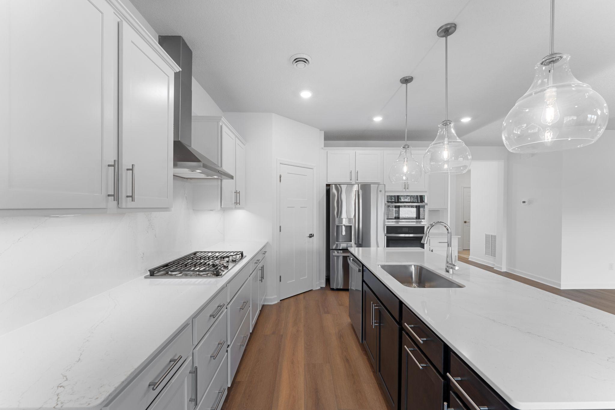 The center island with an undermount stainless steel sink and multicycle dishwasher effortlessly flows to the rest of the home for effortless living