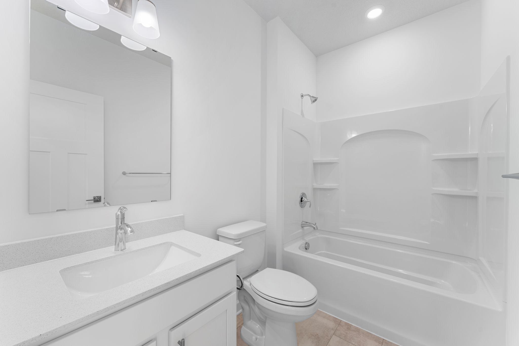 This full-sized bathroom is between the secondary bedrooms and features a single vanity and a shower-tub combination.