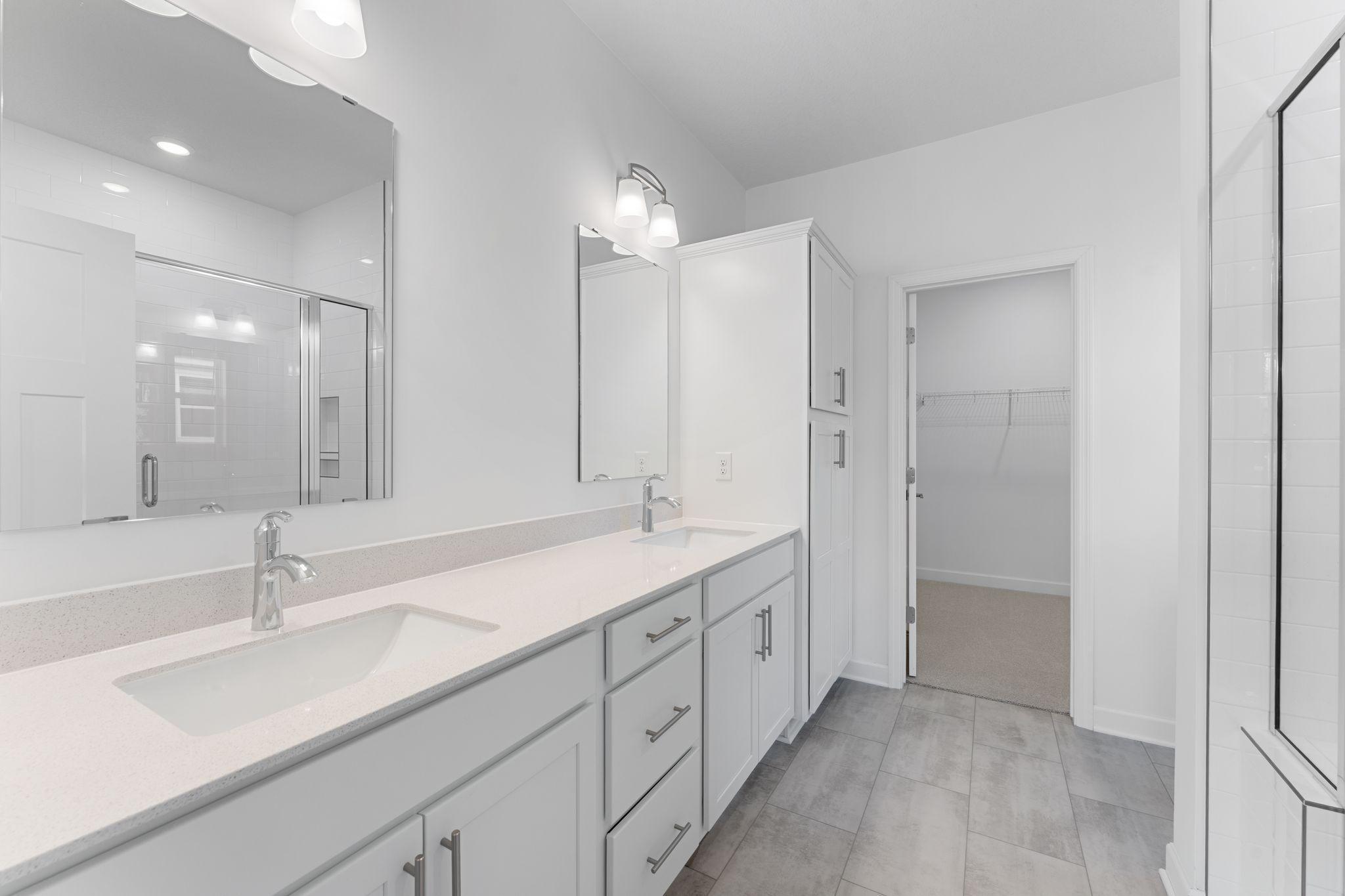 The glass-enclosed shower with full tile surround adds to a spa-like environment