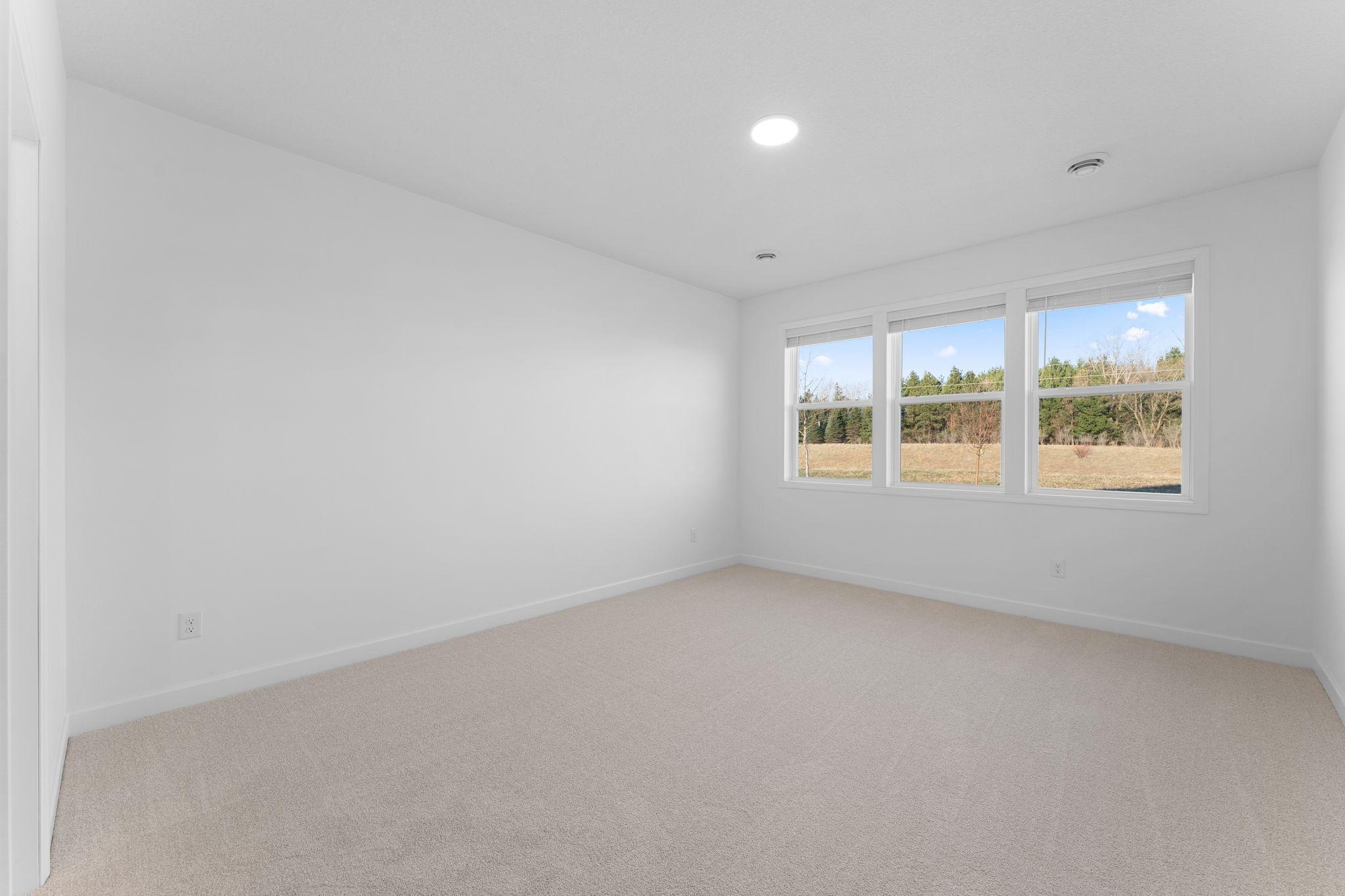 An owner’s suite sits in a rear corner of the home and is a relaxing oasis with an en-suite bathroom and walk-in closet.