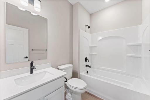 This full-sized bathroom features a stylish vanity and shower-tub combination.