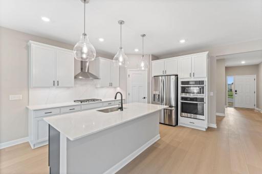 A multifunctional center island pairs with abundant cabinetry and all-new kitchen appliances to create a sleek design perfect for cooking meals of all sizes.