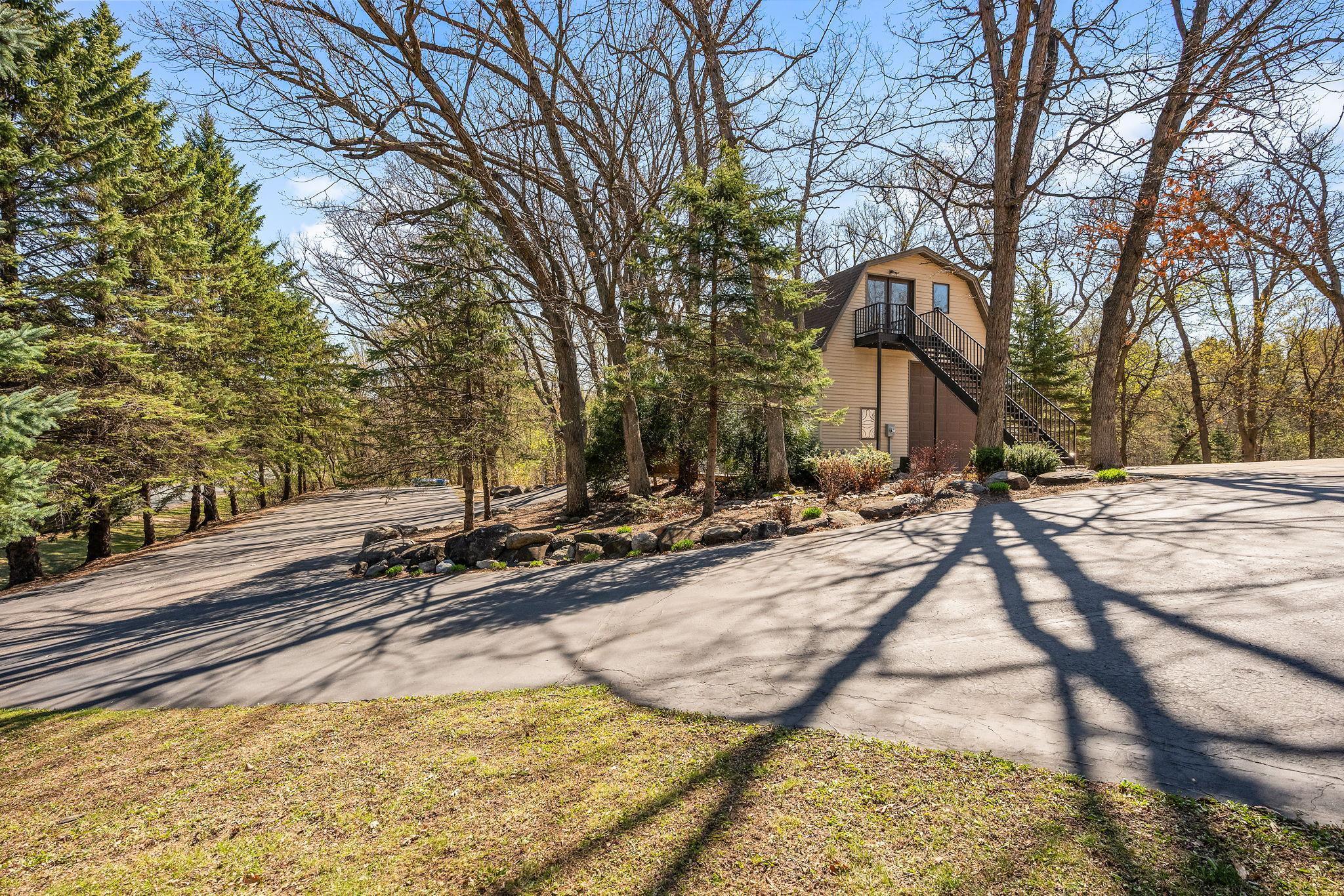 Paved driveway on left goes to another garage door on detached garage & shed