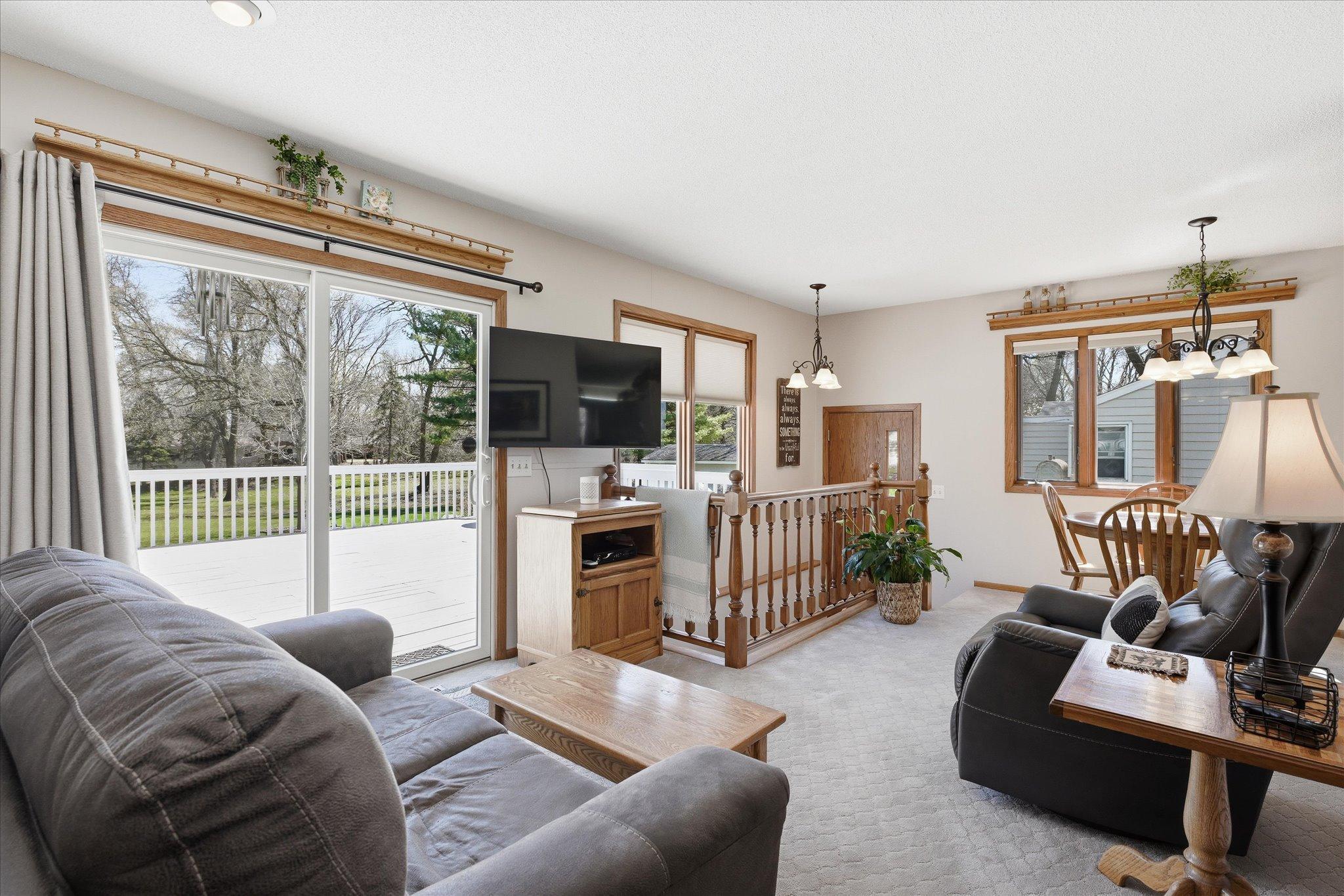 Another view of the family room, dining area and steps that lead to an additional entry and the lower level.