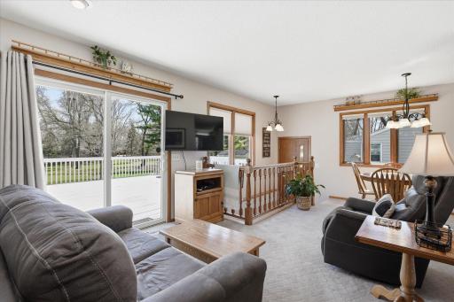 Another view of the family room, dining area and steps that lead to an additional entry and the lower level.