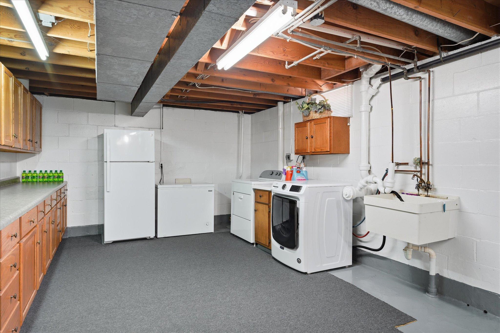 The laundry area is huge and includes a laundry sink and tons of cabinetry