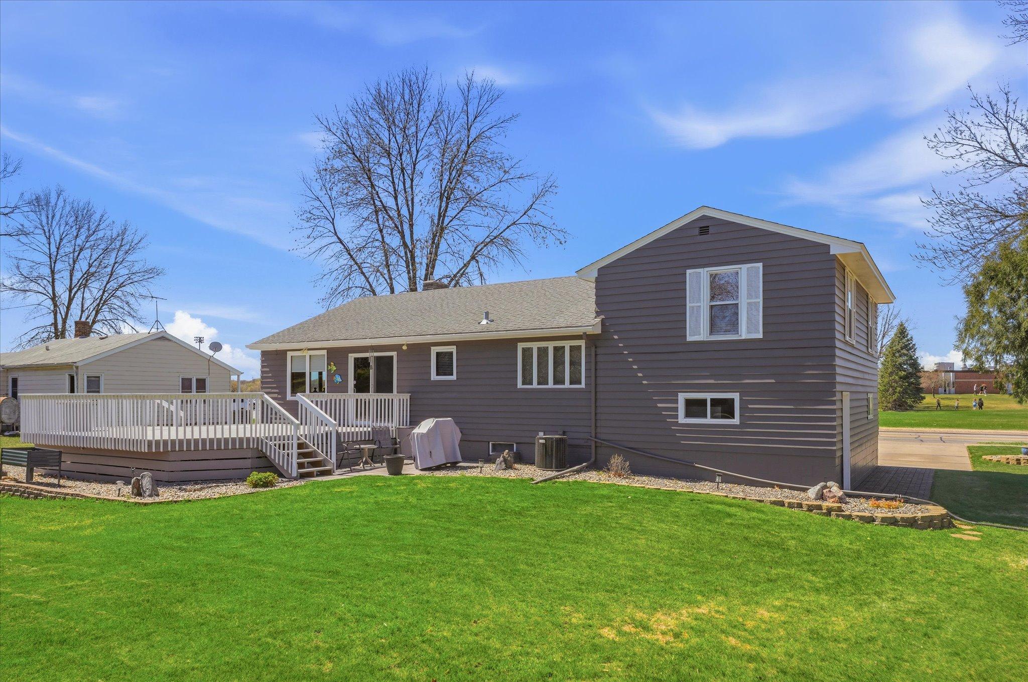 Rear view of the home shows off the landscaping and large deck off of the family room.