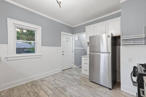 Stainless steel appliances and deck access in the kitchen. There is a coat hanging area to use just inside the door to the backyard. The basement is just ahead through the doorway.