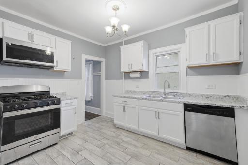 The kitchen is easy to use, with attractive white enamel cabinets, fresh lighting, and plenty of storage space.