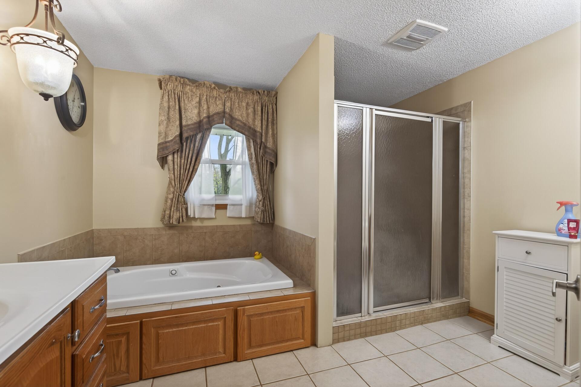 Wonderful Ensuite private primary bathroom with tiled floors, jetted tub and separate shower.