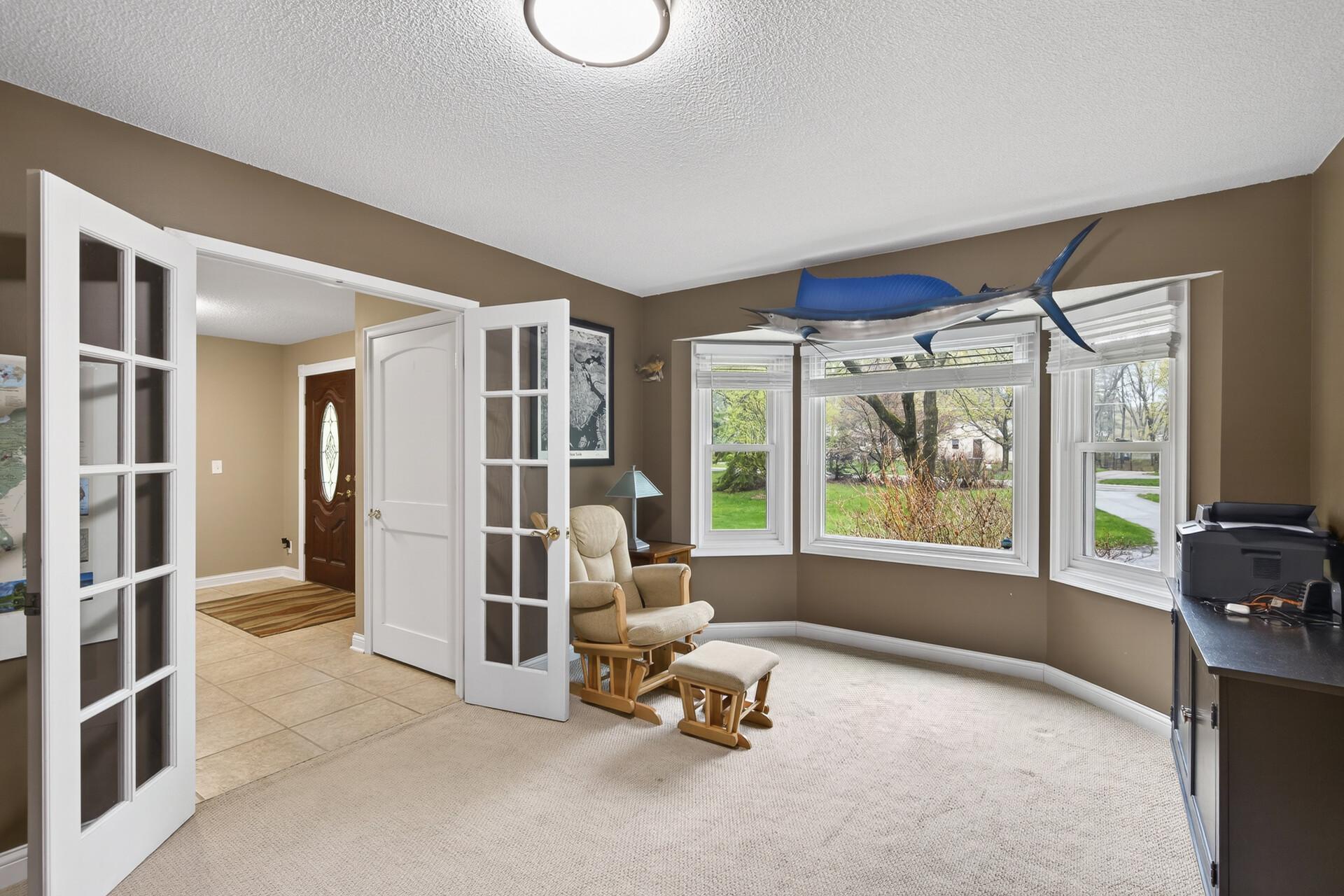 Main floor office w/ glass french doors and a bay window