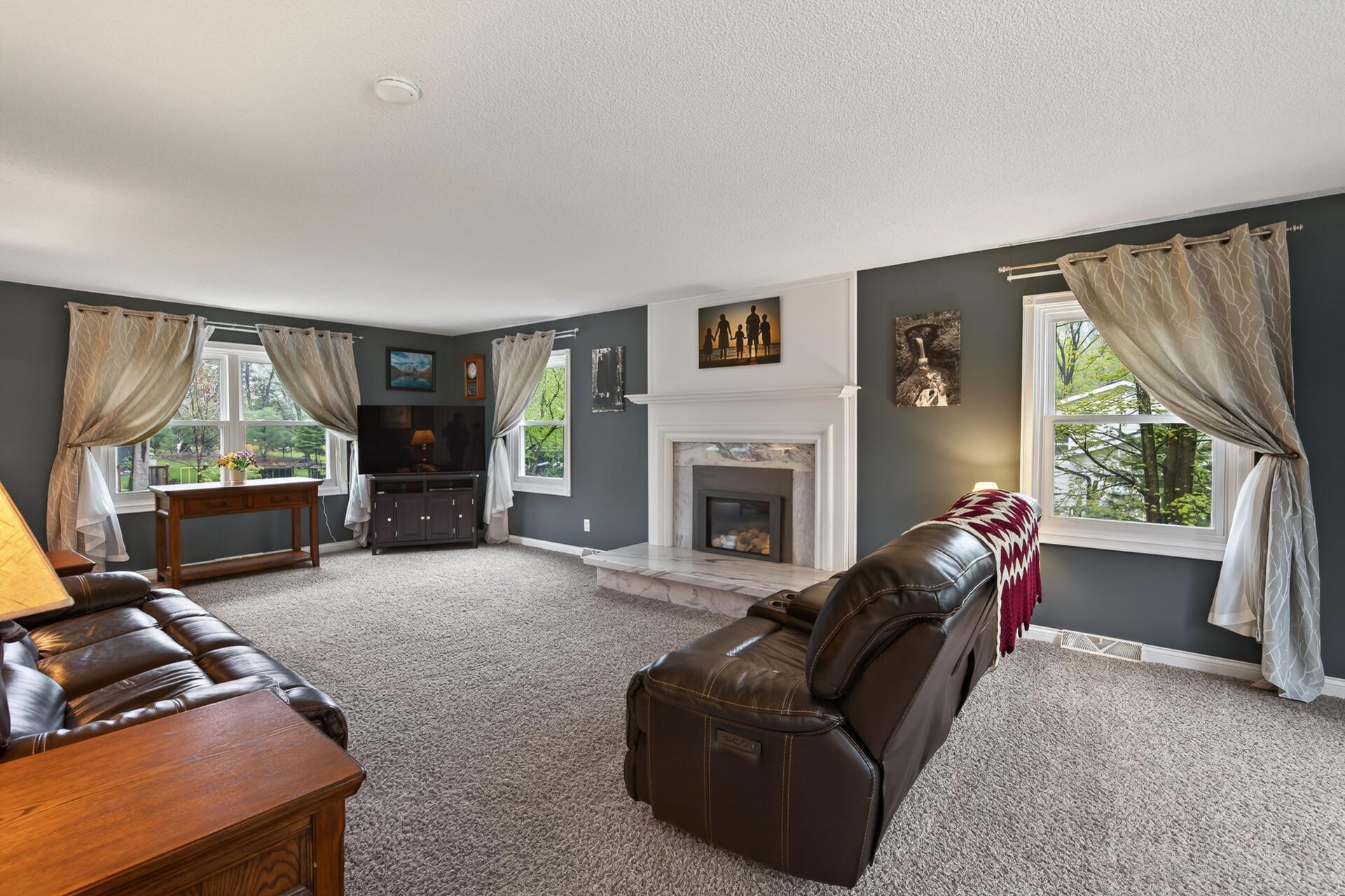 Spacious and bright main floor great room complete with gas fireplace w/ marble surround