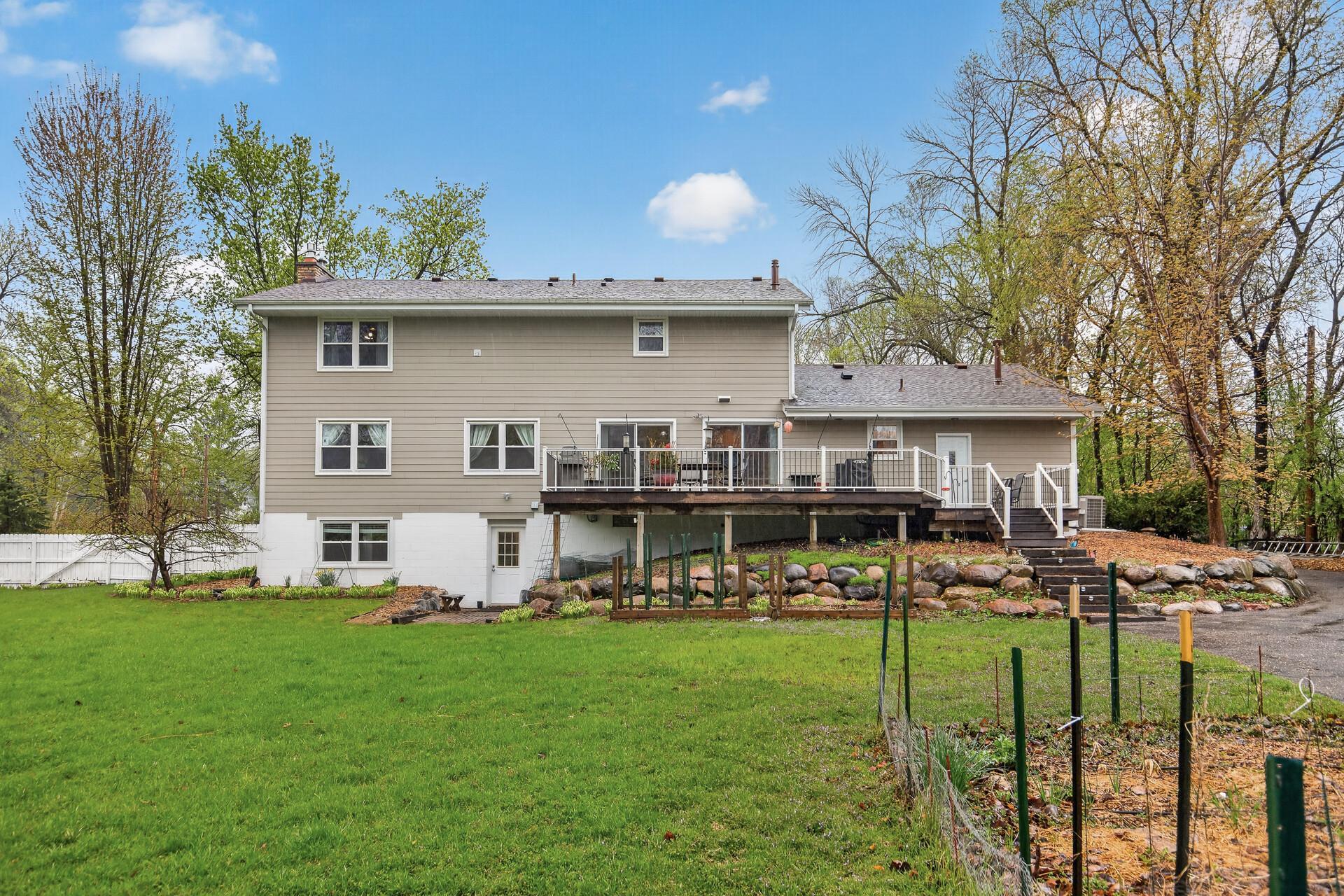Back of the home - Enjoy all the gardens, trees & fenced-in yard