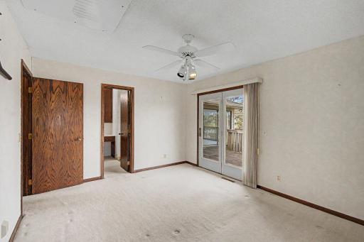 Primary bedroom with access through the French Doors to the backyard deck and there is also a walk through to the full bathroom.