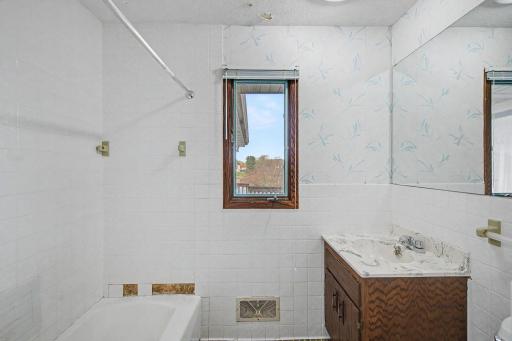 Main level full bathroom with a walk through to the primary bedroom.