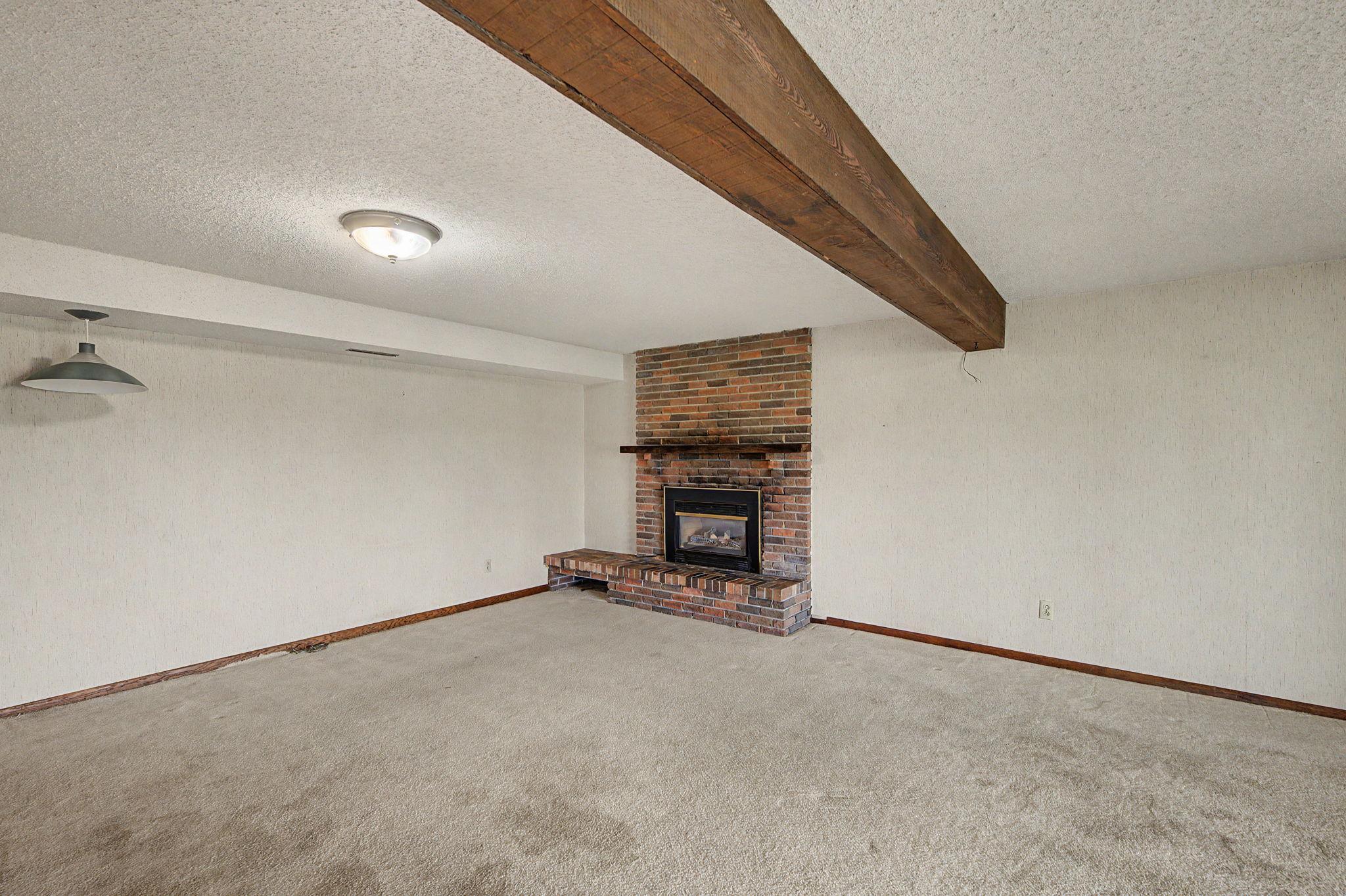 Lower level living room with another fireplace. This is a gas fireplace with an insert and does not currently work.