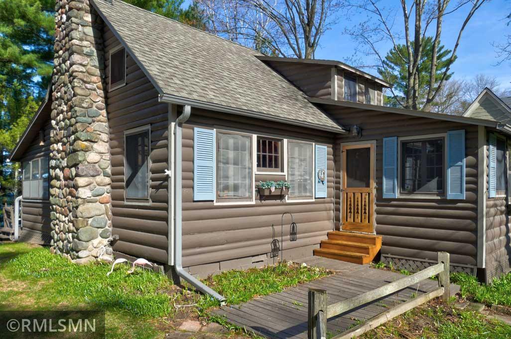Log siding and a stone fireplace on this seasonal cabin.