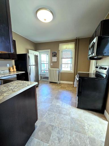 This bright and updated kitchen has stainless steel appliances and offers ample space