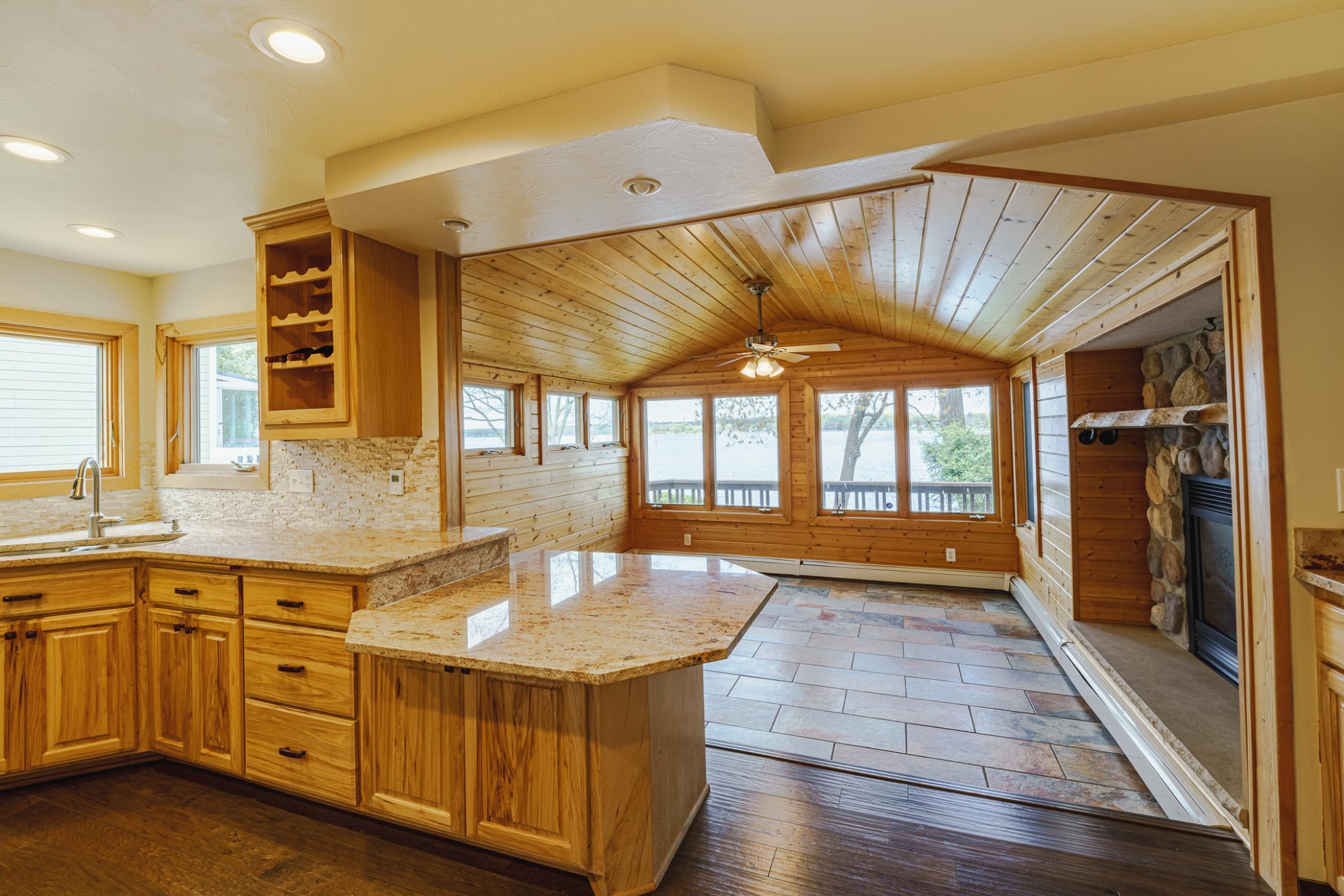 The vaulted sunroom is just beyond the kitchen. There is places for stools at the seating bar.