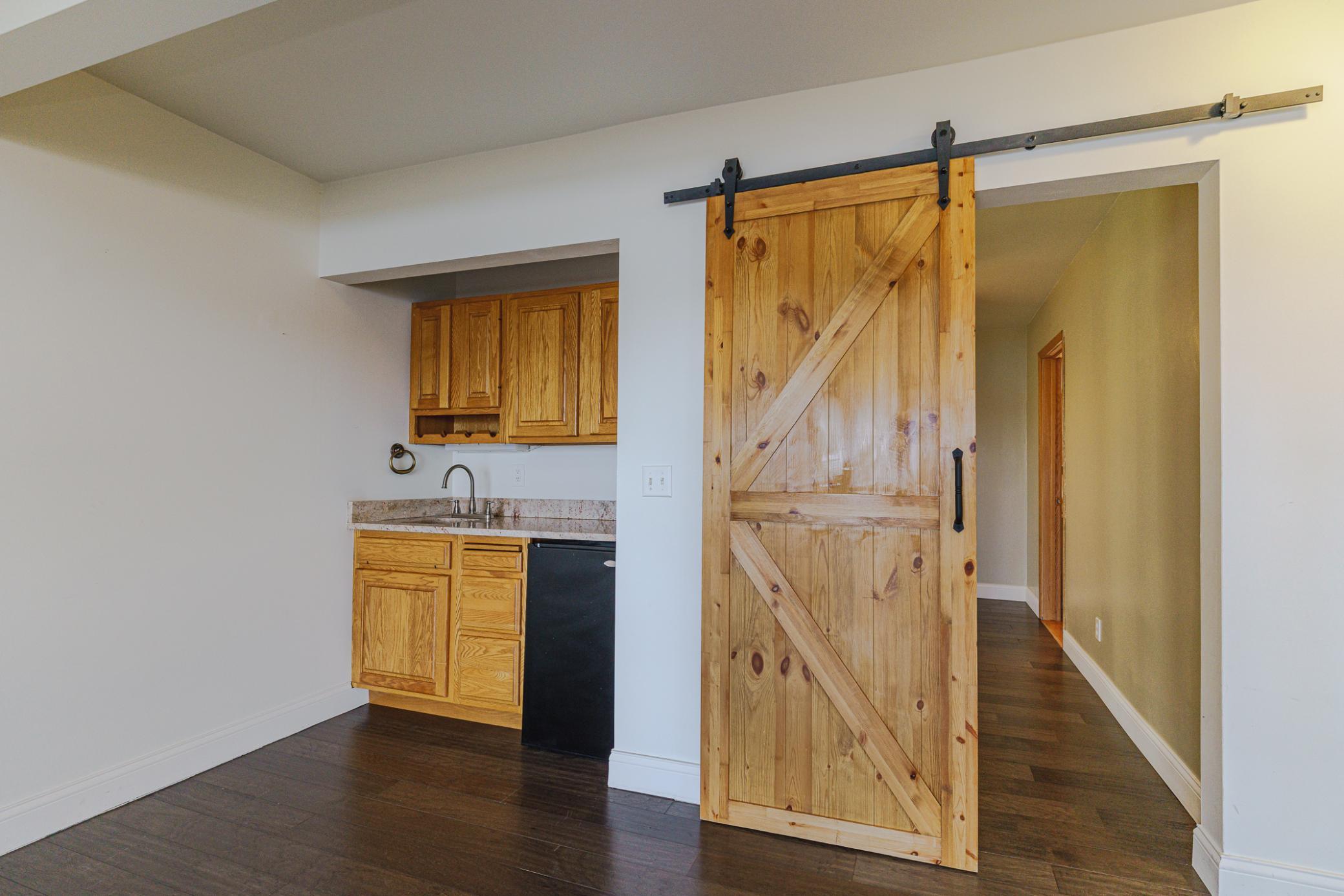 The main floor living room has a wet/serving bar and a sliding barn door to the main floor bedroom, which could also be used as an office.