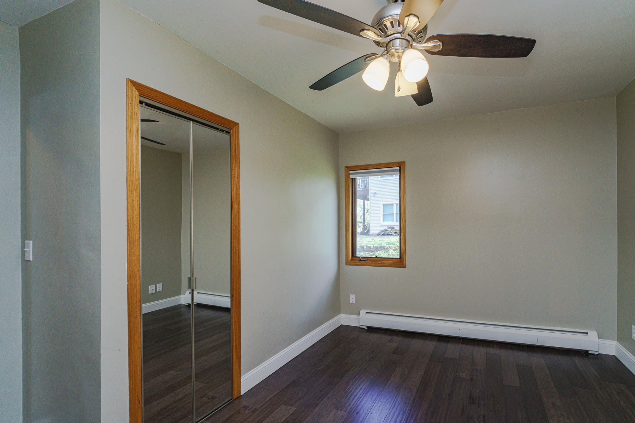 Main floor bedroom/office option with a ceiling fan and white trim. This bedroom has an attached bathroom.
