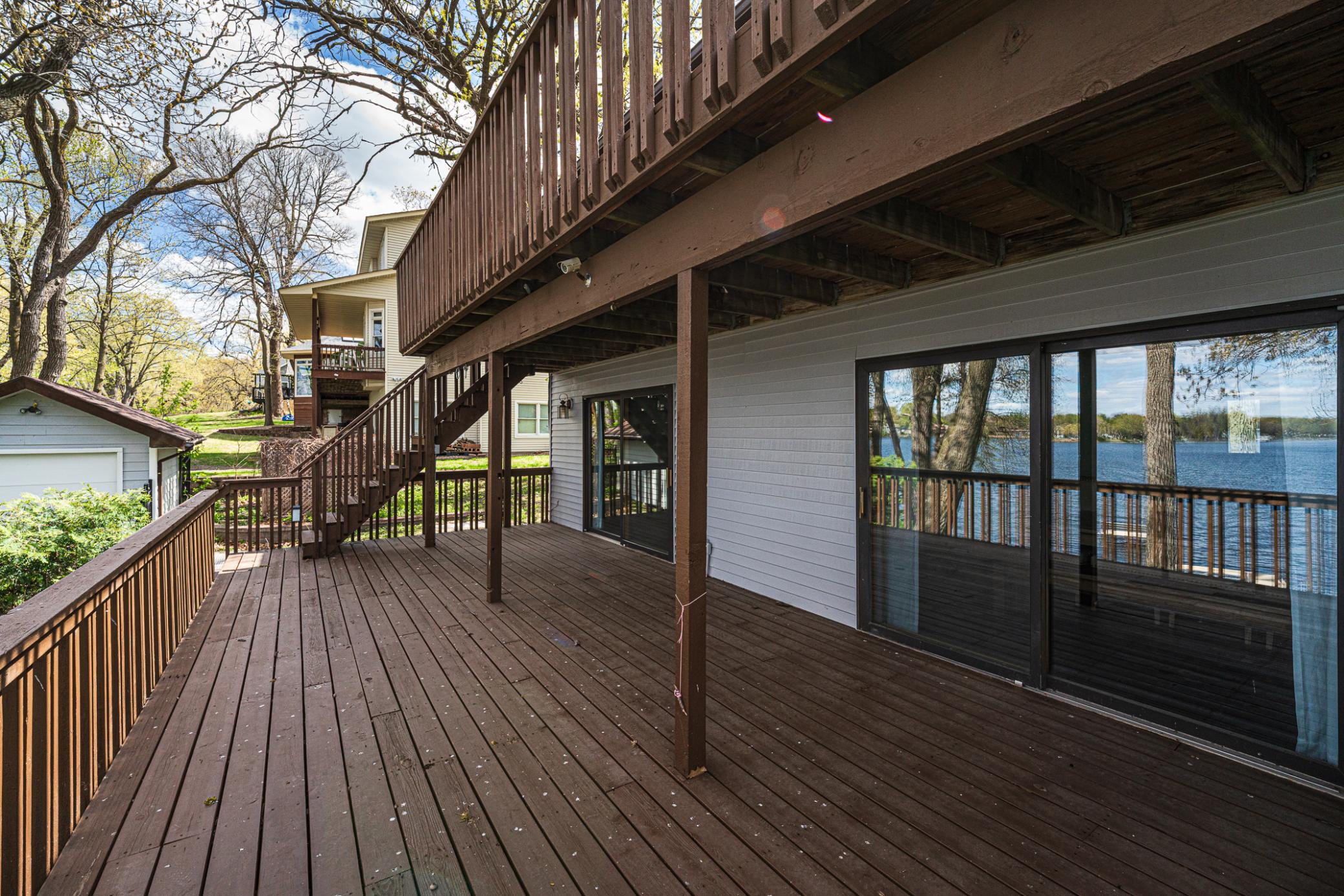 Reflections of the lake shine off the patio doors on the deck of this lakefront home.