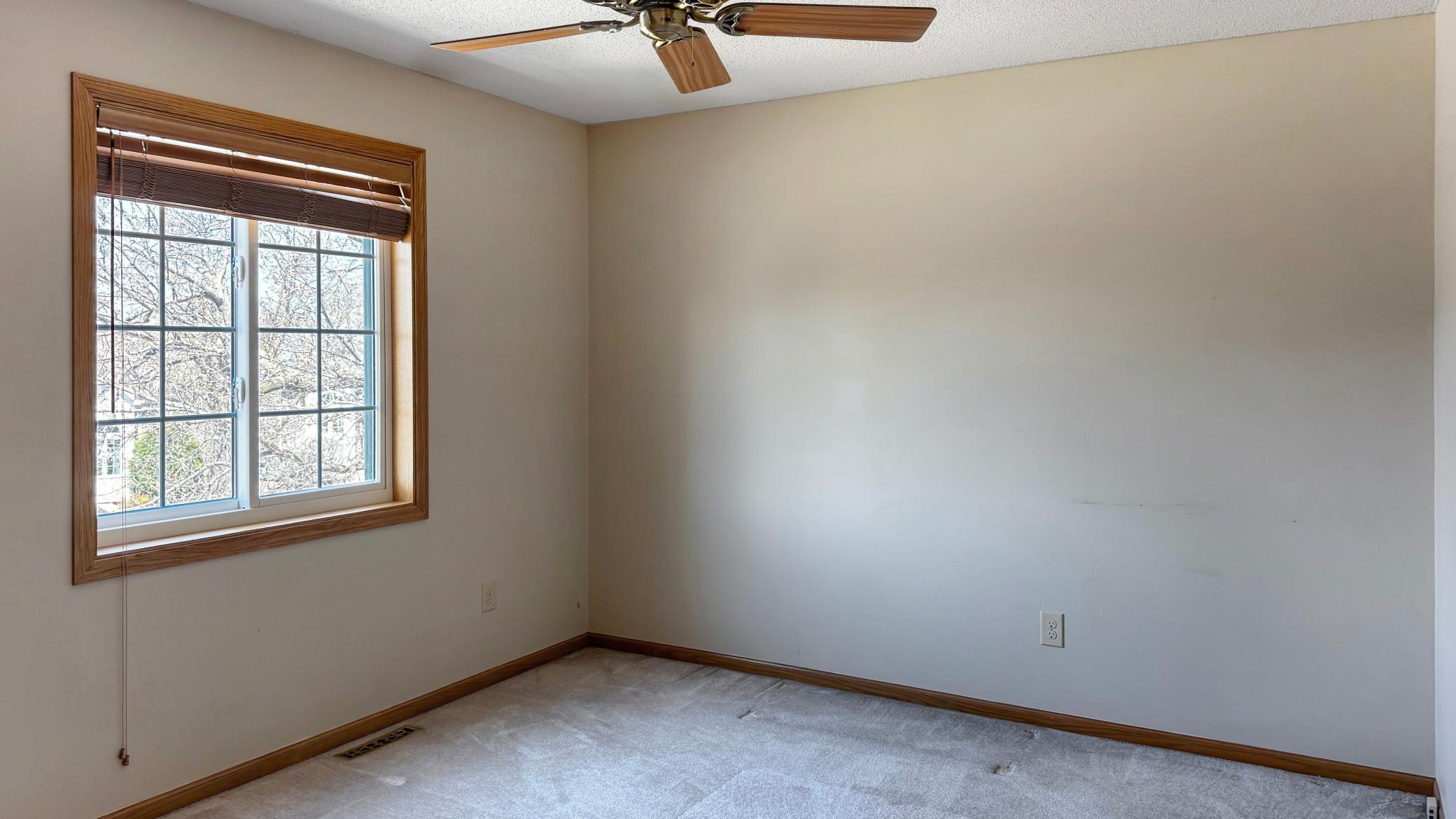 The 2nd bedroom upstairs is large, with a ceiling fan and big window