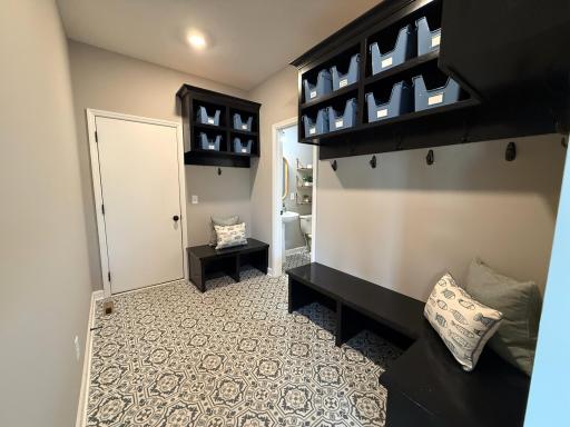Keep things tidy in this home with a roomy mudroom complete with built-in coat hooks, seating, and cubbies for the whole family. A handy half bath is located just off the mudroom for added convenience.
