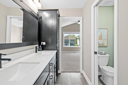 Owners Suite bath features dual sinks, quartz counter, separate water room, large walk in closet and a makeup area with seating
