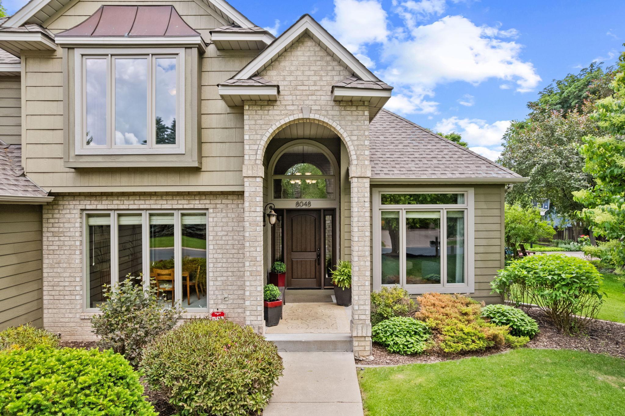 The extended vertical brick arches, protected front porch and deep espresso finish on the Therma-Tru front door provide a memorable first impression!