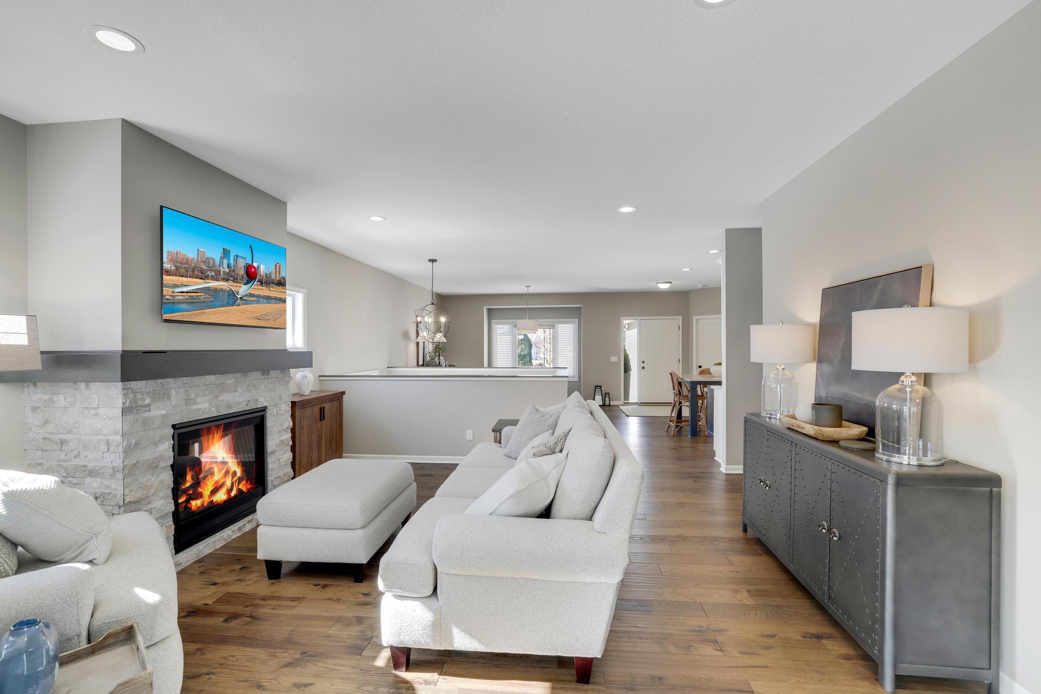 The living room, anchored by a stunning stone gas fireplace, flows right into the sunroom.
