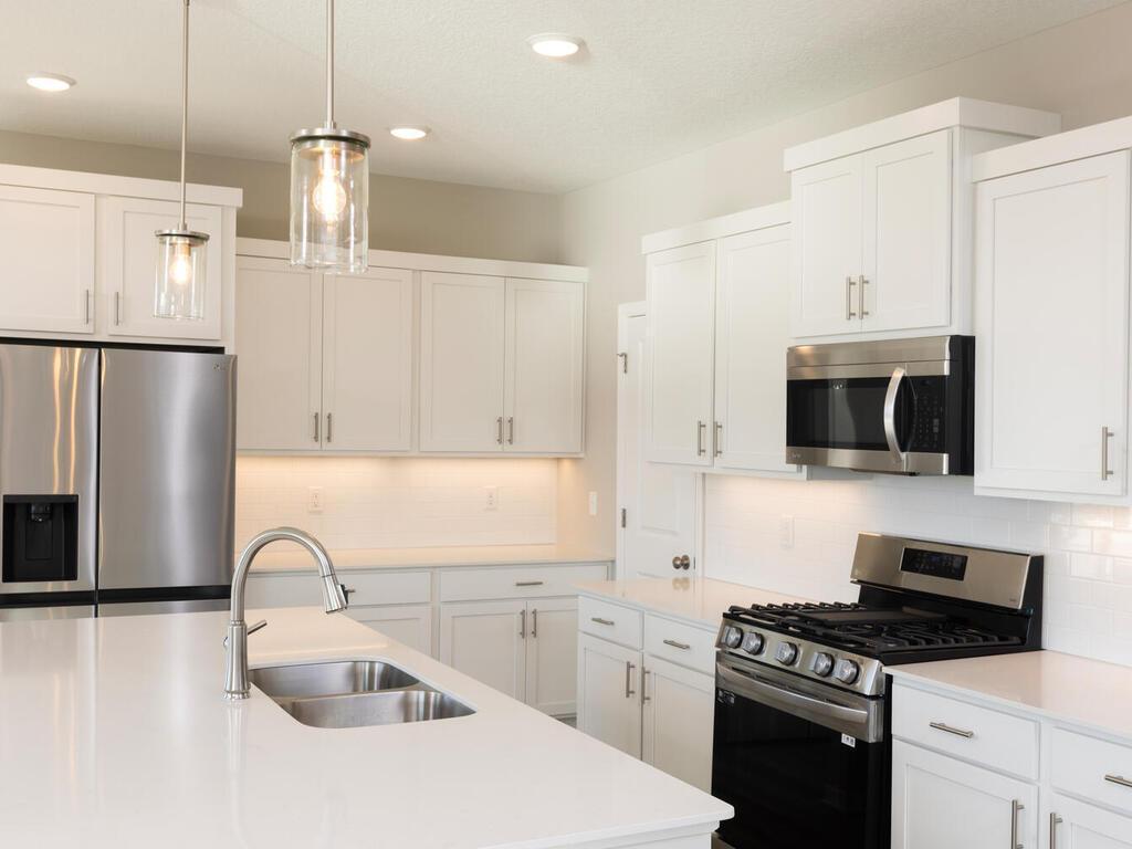 PHOTO OF A DIFFERENT HOME WITH SIMILAR PLAN. FINISHES MAY VARY. Kitchen features a Walk-in Pantry.