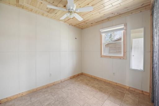 New bedroom window and knotty pine ceiling.