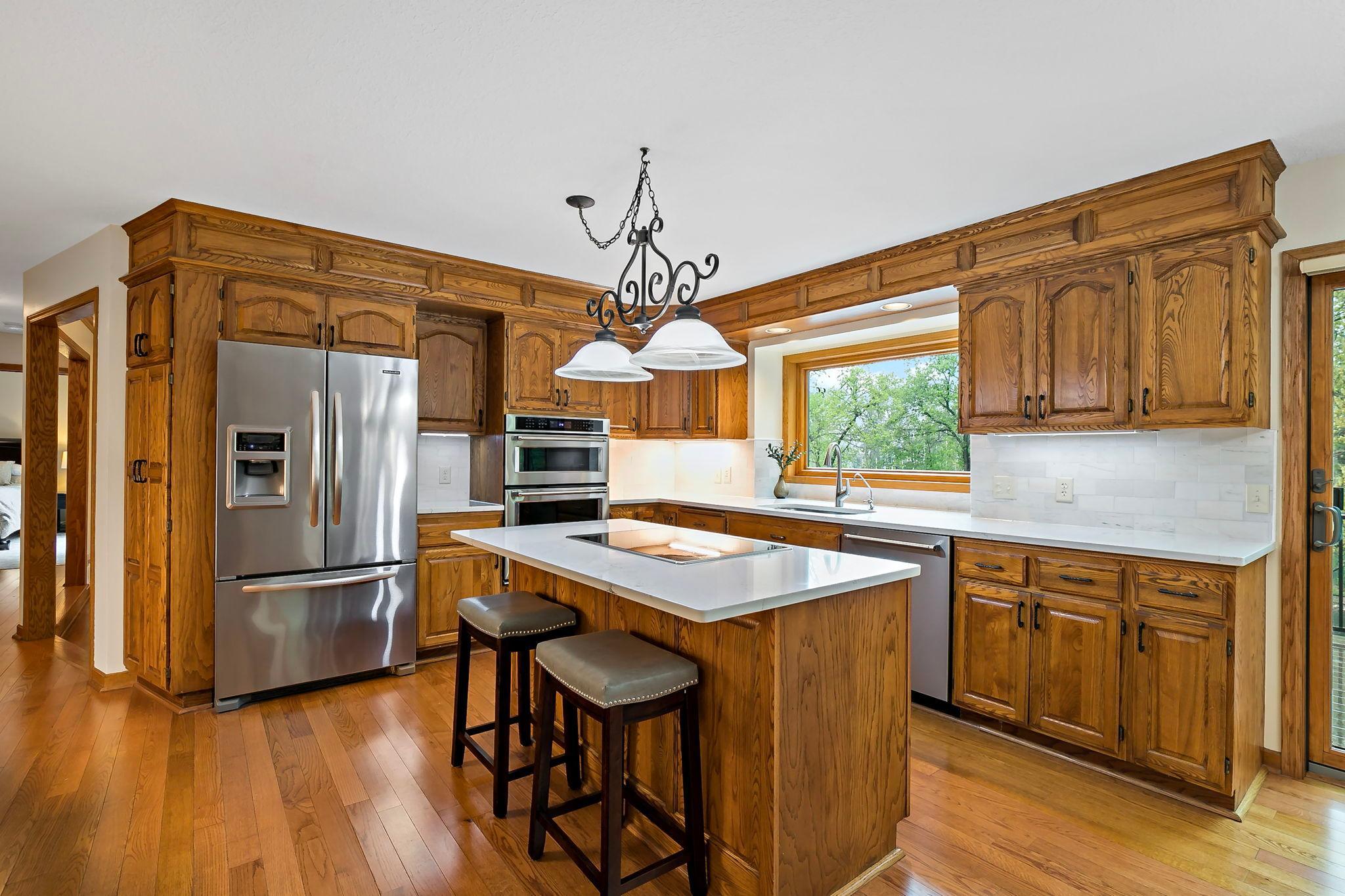 All newer Kitchen Aid stainless appliances, including an induction cooktop and double oven/convection-microwave. Water filtration system added along with crisp white quartz countertops and tile backsplash.