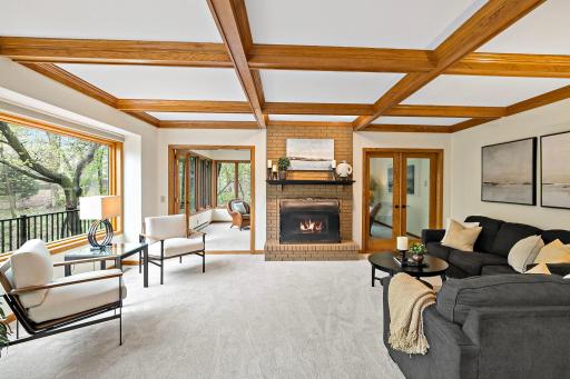 Enjoy the character and warmth of this lovely gathering space with box beam ceilings and gas fireplace, along with double door entry to the sunroom beyond.