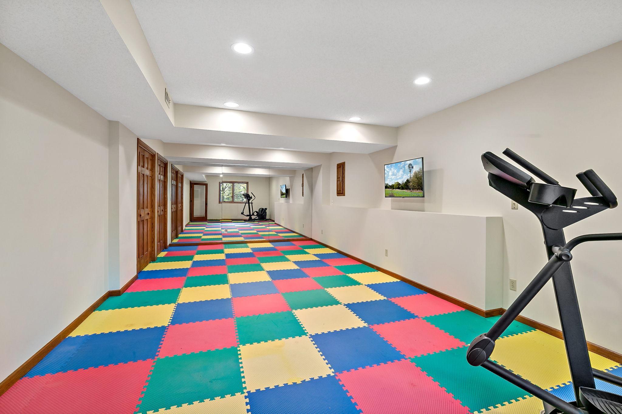 Working out is a breeze in this enormous exercise room with cushioned mats (convertible to gray if primary colors aren't your thing;) and wall-mounted TV. With two more large closets this room can also serve multiple purposes to suit your needs.