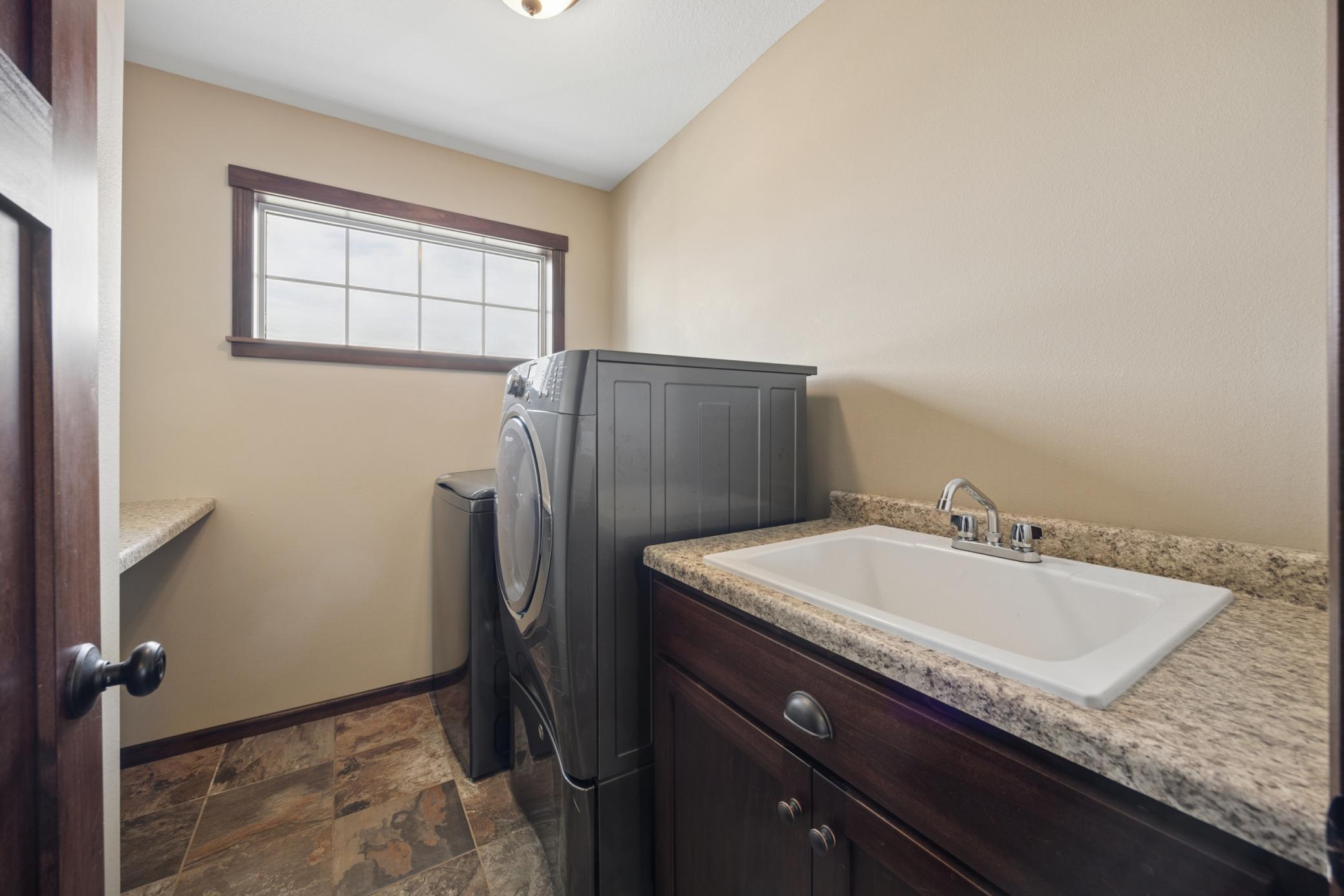 Convenient upper level laundry room also includes a sink