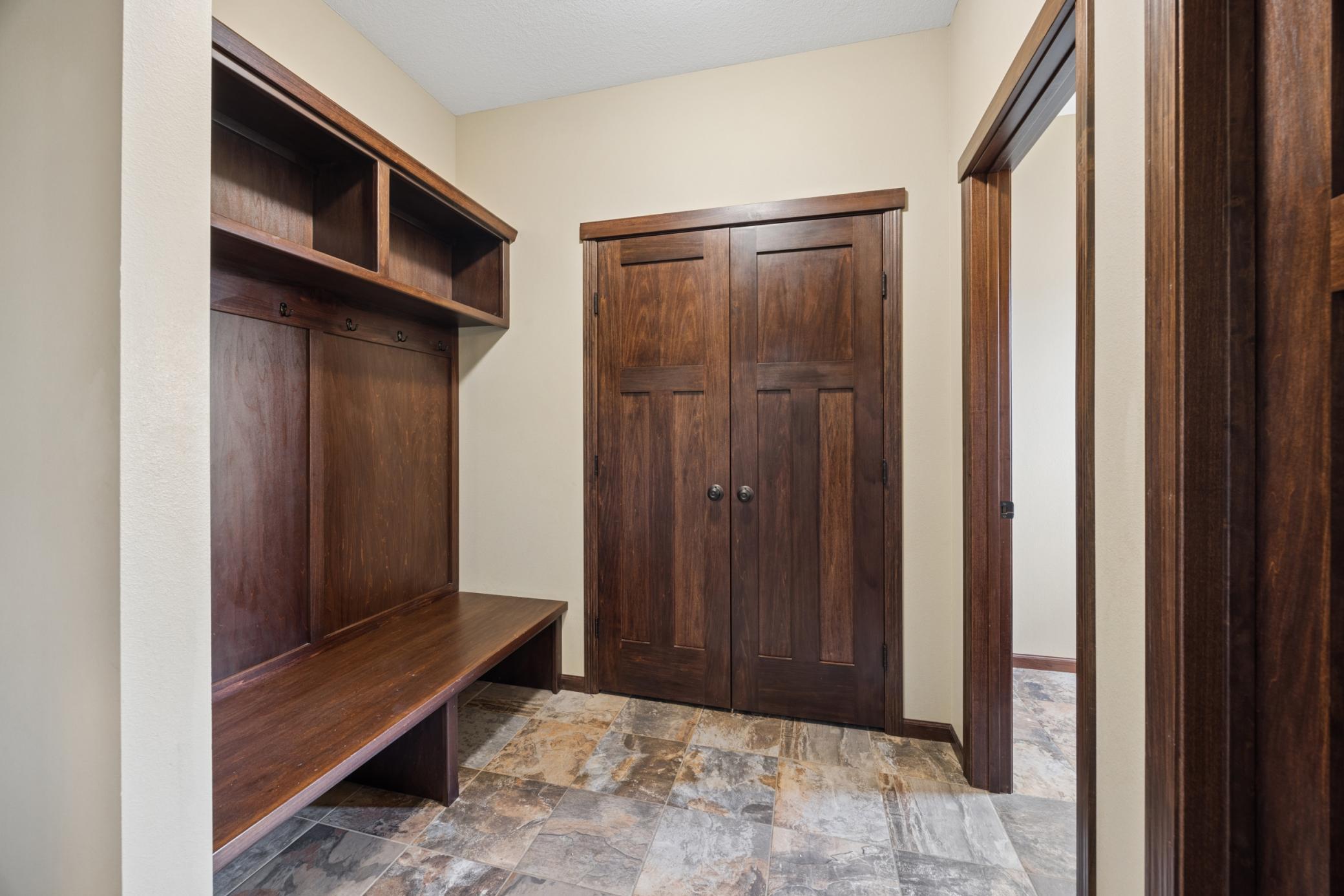Thoughtfully designed mudroom, complete with built-in storage, access to the garage