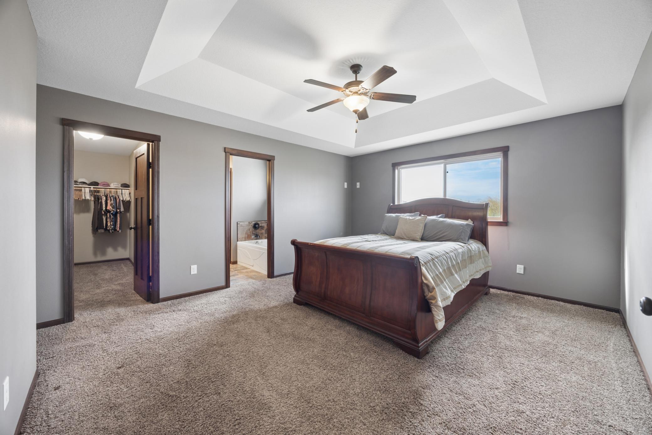 Generously sized primary suite designed as a true retreat. Enjoy the elegance of a tray ceiling and a lighted ceiling fan.