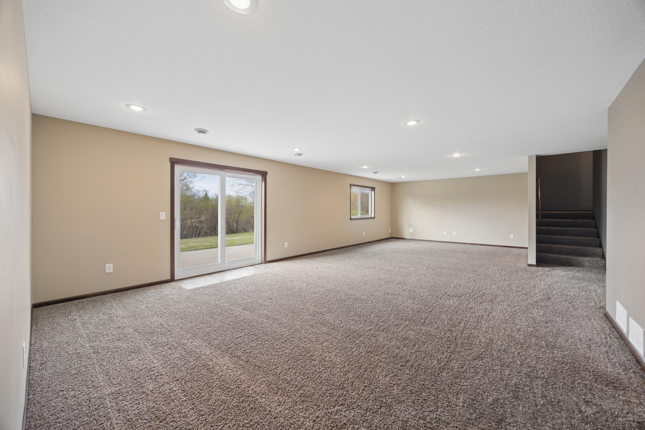 Walk-out lower level family room has soft carpeting that adds both style and comfort.