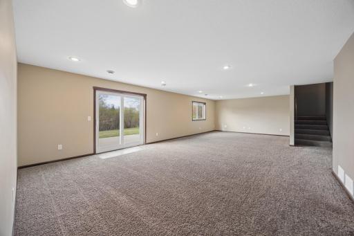 Walk-out lower level family room has soft carpeting that adds both style and comfort.