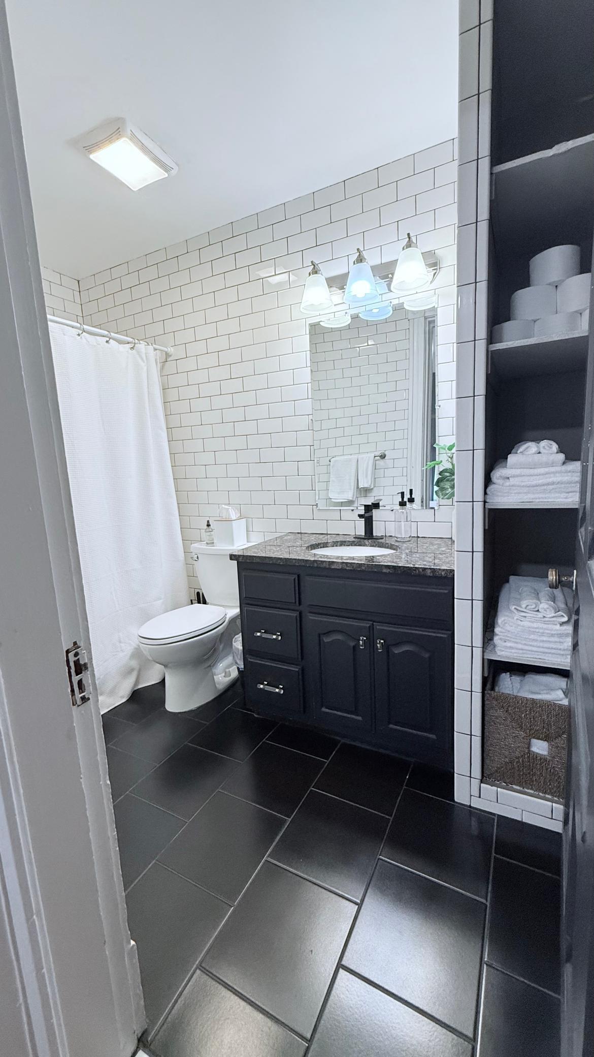 Updated Airbnb bathroom with full tile wall.jpg