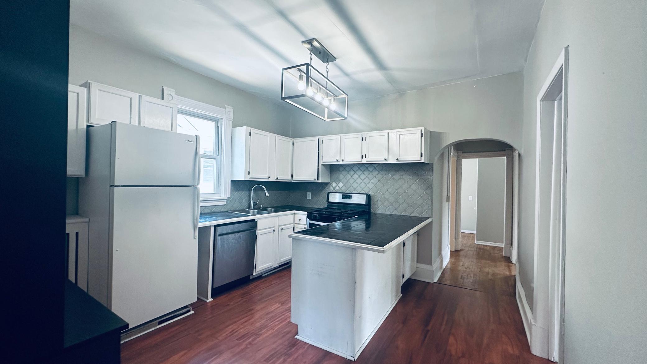 3 bedroom/upper level unit kitchen with large peninsula, and tile backsplash