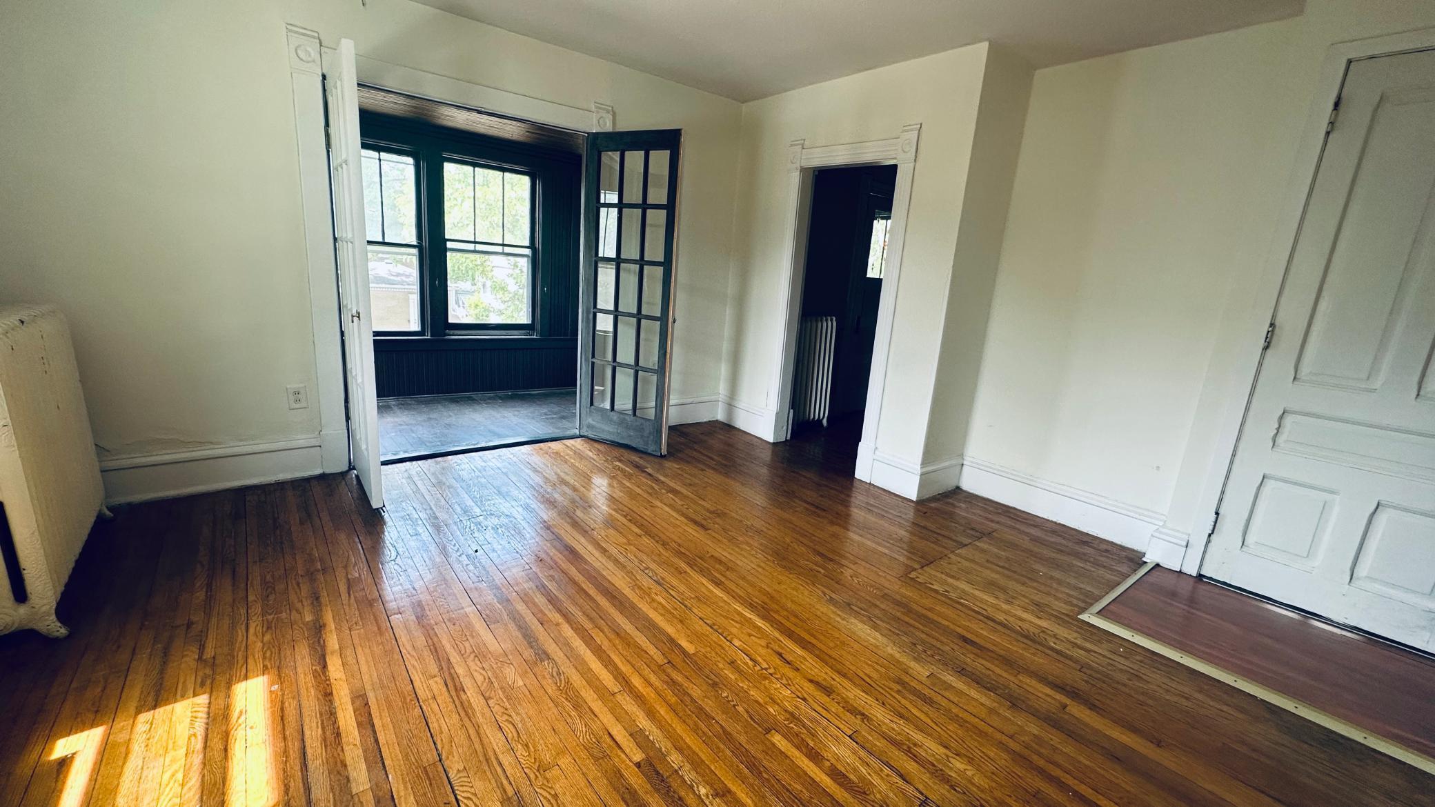 Beautiful hardwood floors throughout, french doors out to the sunroom, showing door to front entrance off Fremont Ave