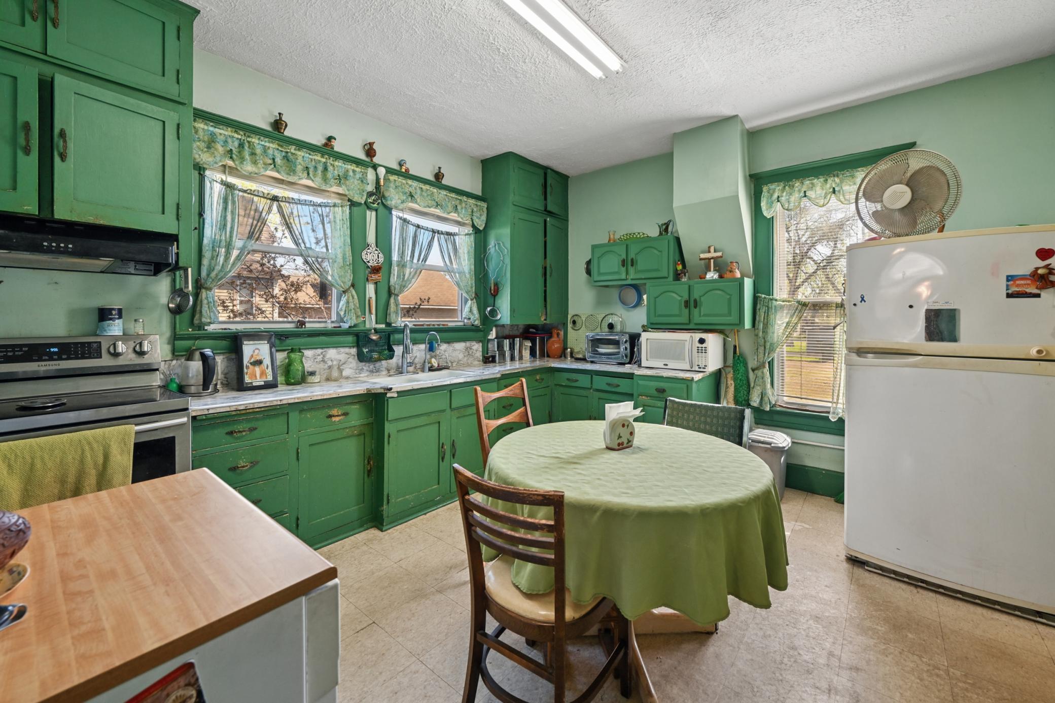 The bright kitchen features windows with views of the backyard.